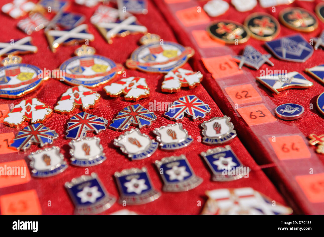 Loyalist/Unionist badges on sale at a market stall beside an Orange Order parade Stock Photo