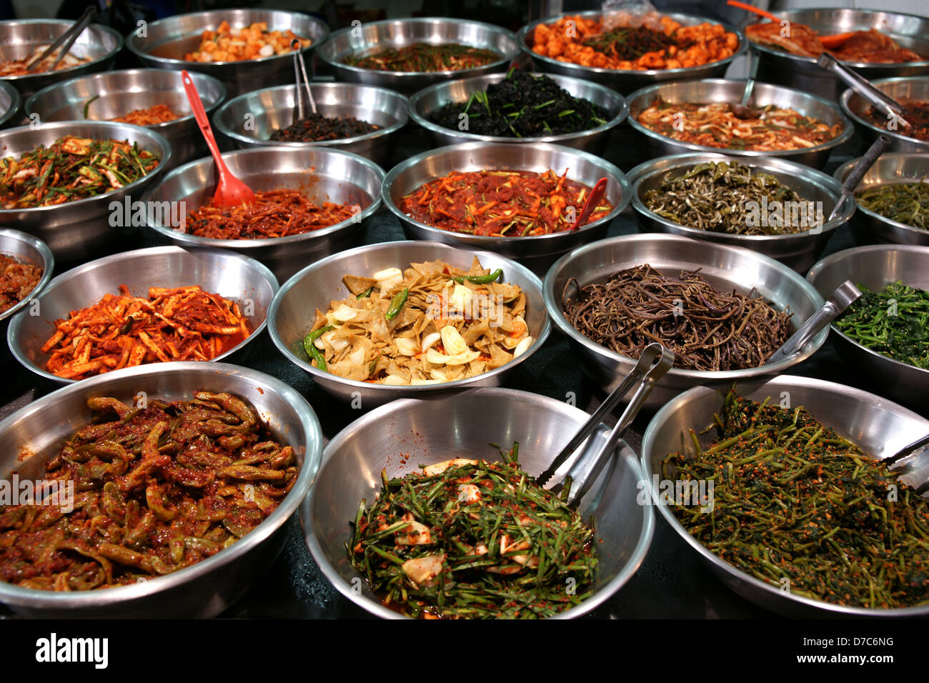 Metal bowls full of various fermented vegetables (kimchi). Photo taken on a Korean traditional food market in Suwon, South Korea Stock Photo