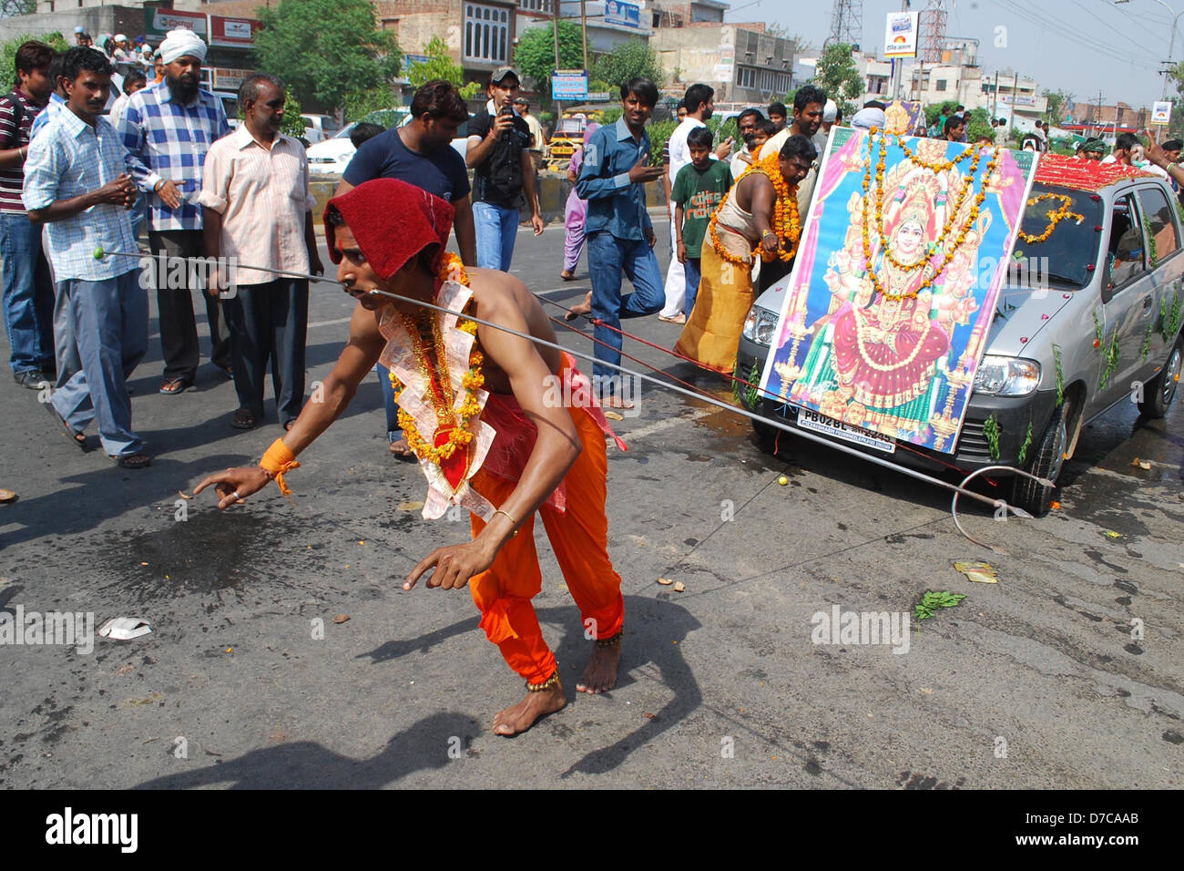 A Hindu devotee pulls a car with ropes, attached to hooks, piercing his back, as he takes part in a religious procession Stock Photo