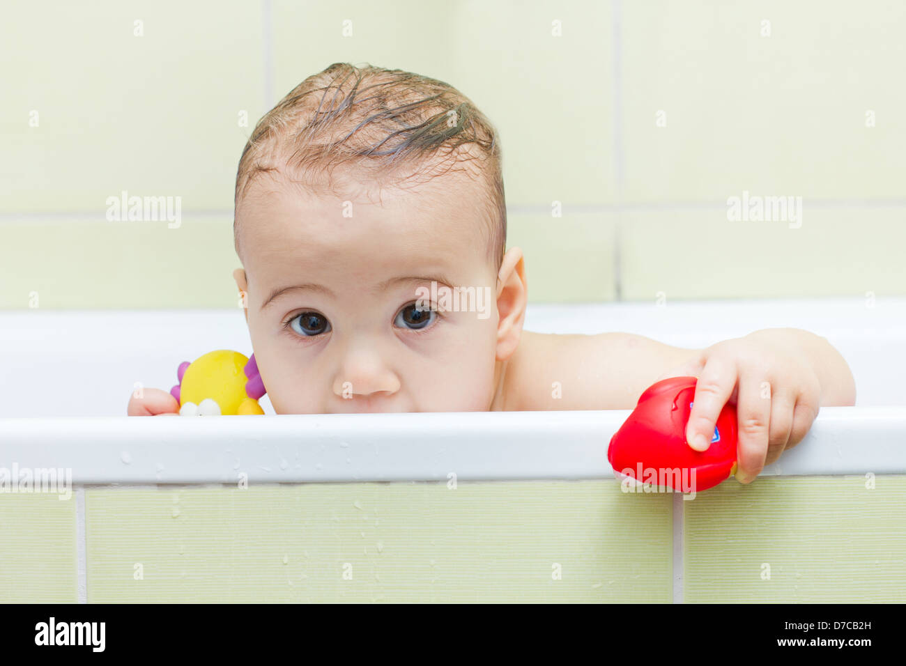 Baby peeking out of the tub while bathing Stock Photo Alamy