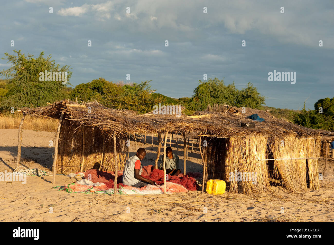 Fishermen fixing nets on the beach, lake Niassa, Mozambique Stock Photo