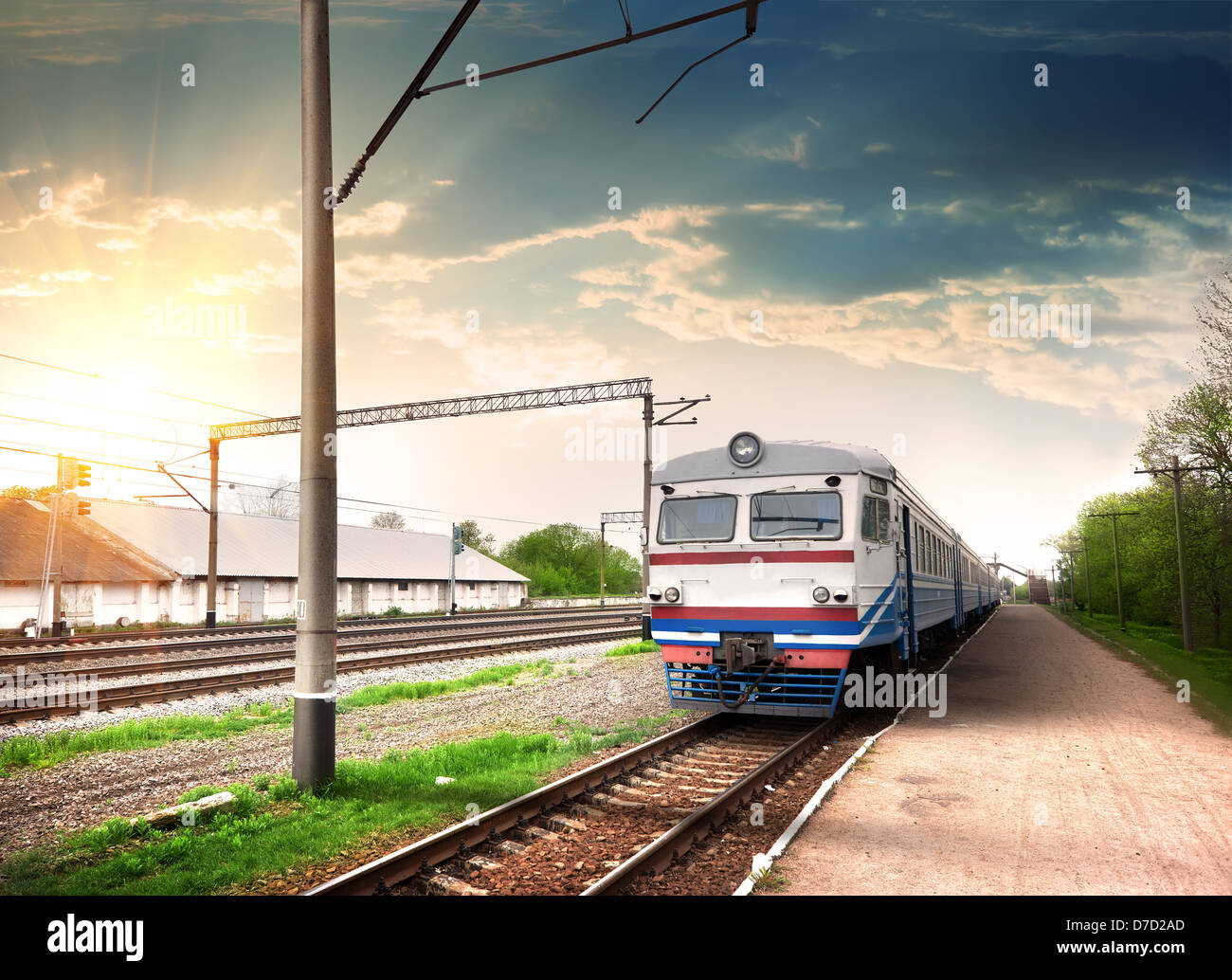 Modern train at a railway station in the rays of the sun Stock Photo