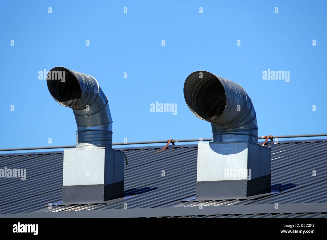 Pipes of ventilation are located on a roof of a building Stock Photo