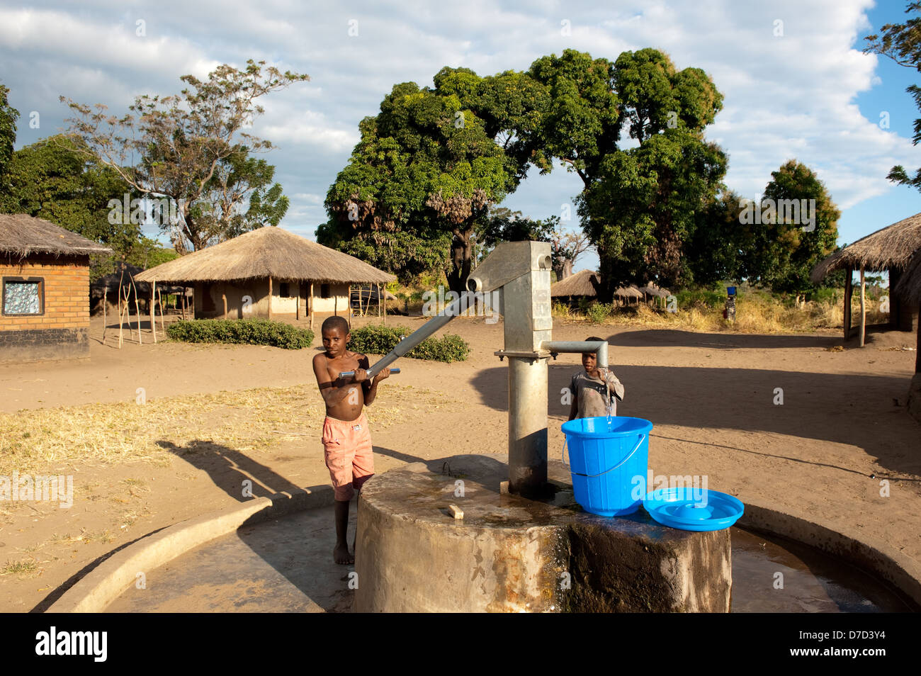 Boy pumping water from a well, lake Niassa, Mozambique Stock Photo