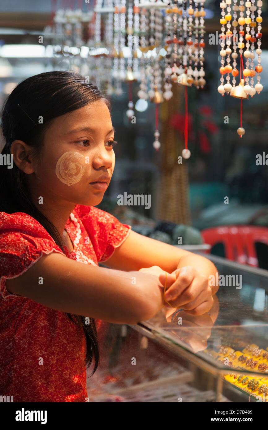 A young Burmese girl with Thanaka face decoration in Bogyoke (formerly Scott) Market in Yangon, Myanmar 6 Stock Photo