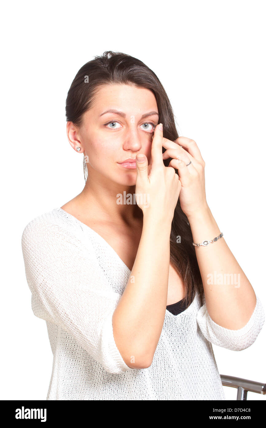Young woman inserting contact lenses to eye Stock Photo