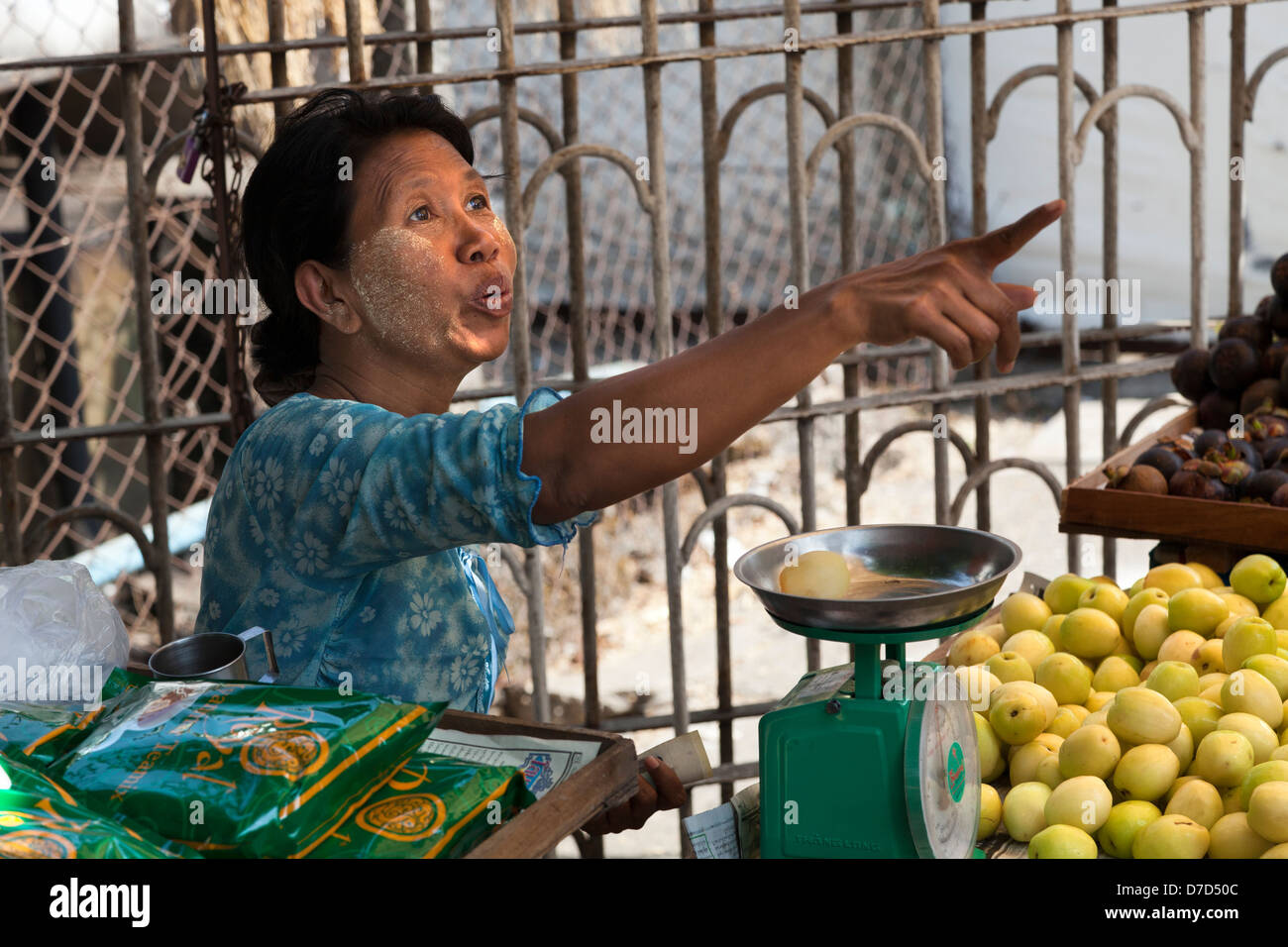 Old woman in fruit stall pointing in Bogyoke (formerly Scott) Market in Yangon, Myanmar Stock Photo