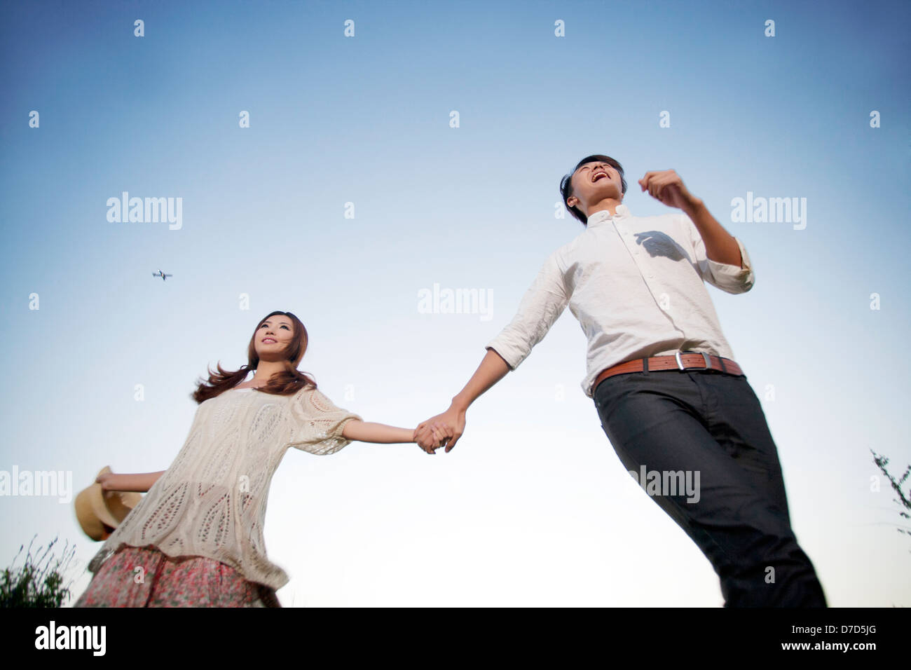 Young couple walking hand in hand Stock Photo - Alamy