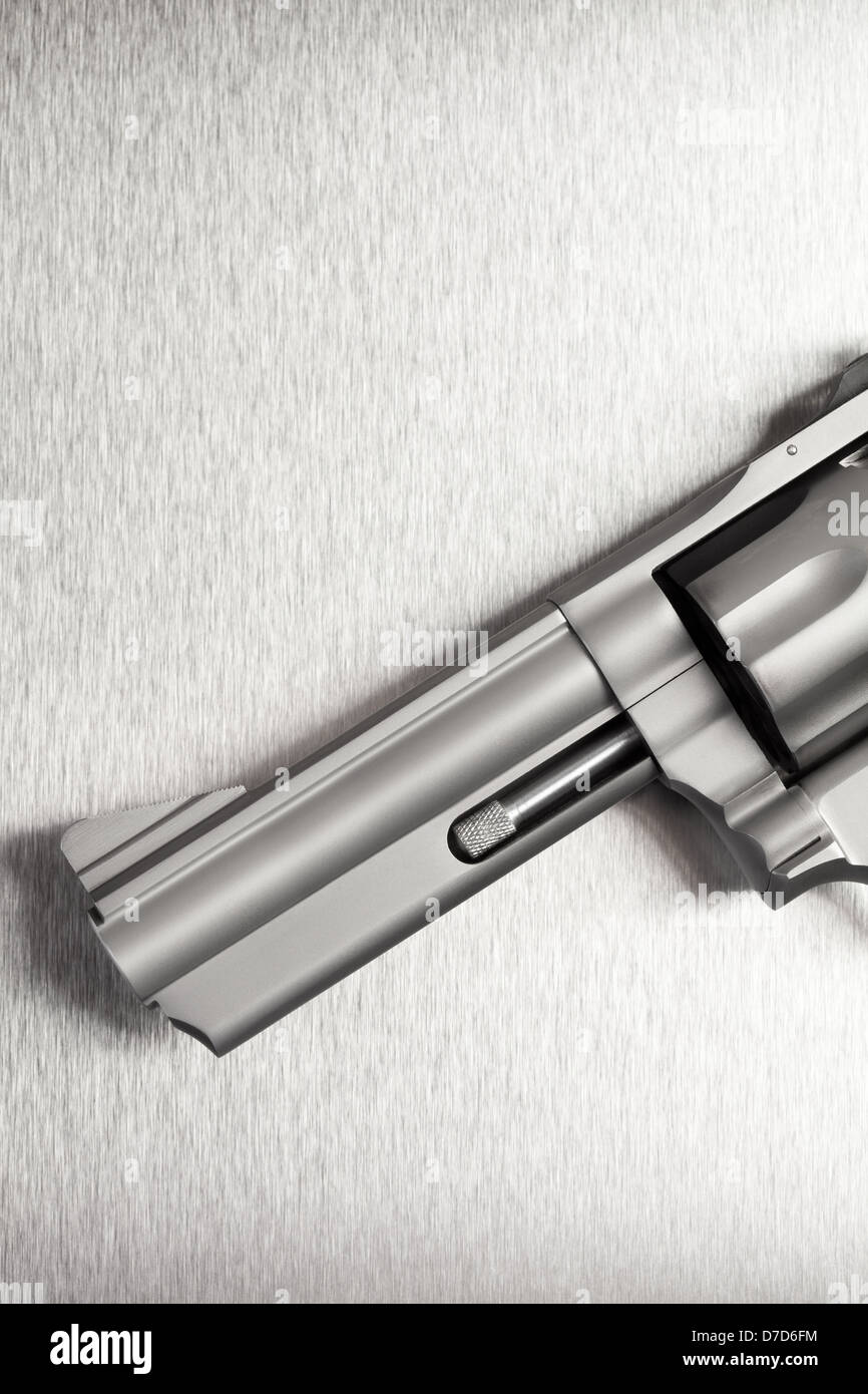 Gun on brushed metal background - a modern revolver. Stock Photo
