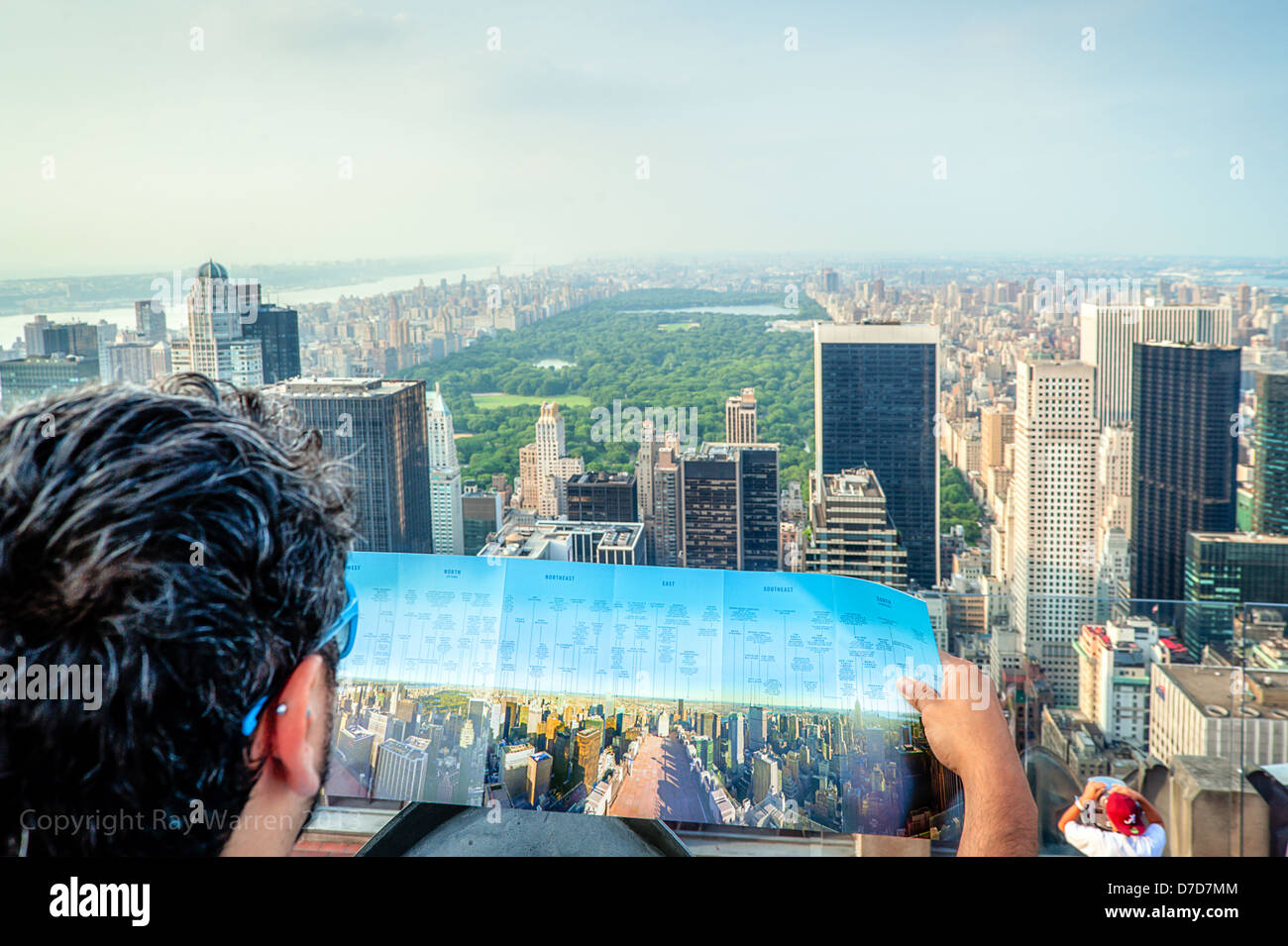 A tourist compares his map to the spectacular view of Central Park in New York City from Top of The Rock, Rockefeller Centre Observation Deck. Stock Photo