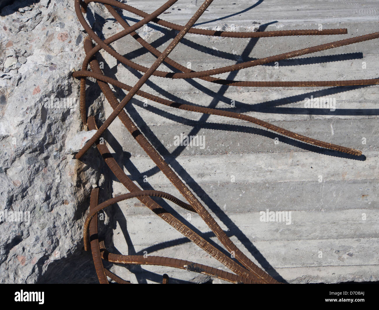 Gray concrete with rusty bent iron support rods sticking out Stock