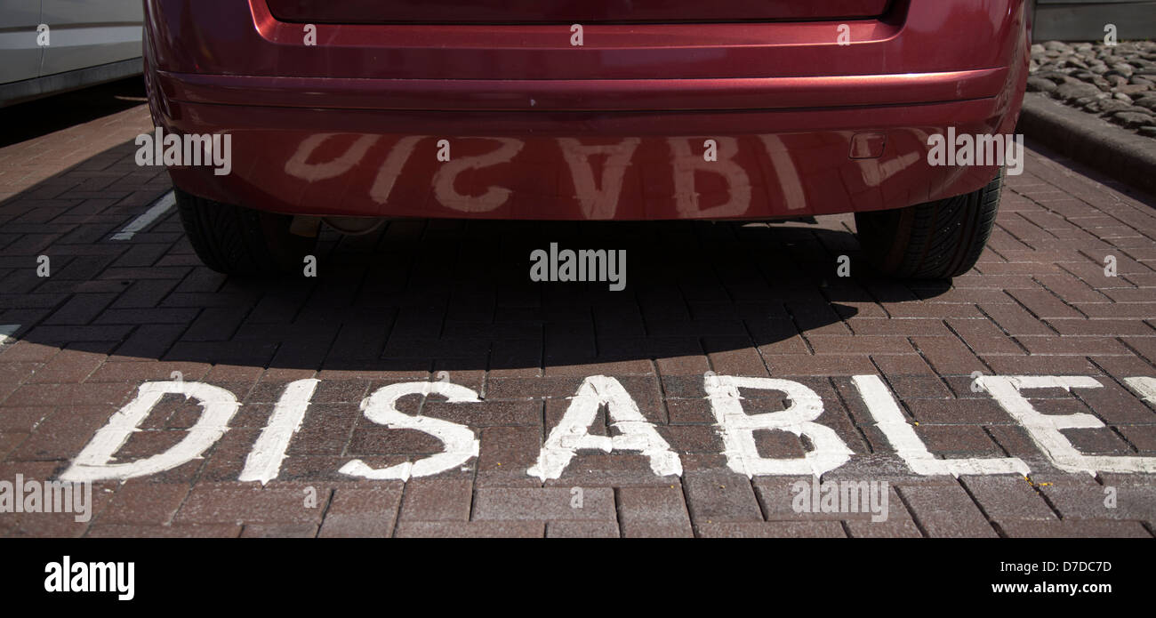 Disabled car parking space, with reversed reflection in car bodywork, Darlington, North Yorkshire, UK Stock Photo