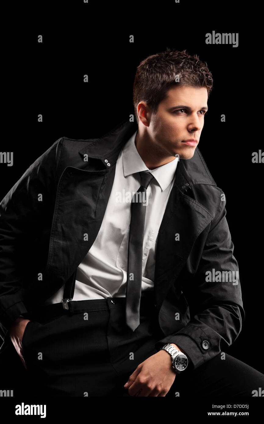 A fashionable young man with a jacket and tie posing isolated against ...