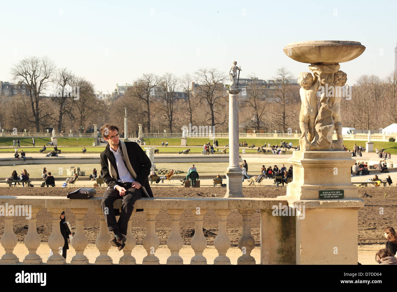 Man sitting on the stone fence in the Luxembourg garden, Paris, France Stock Photo