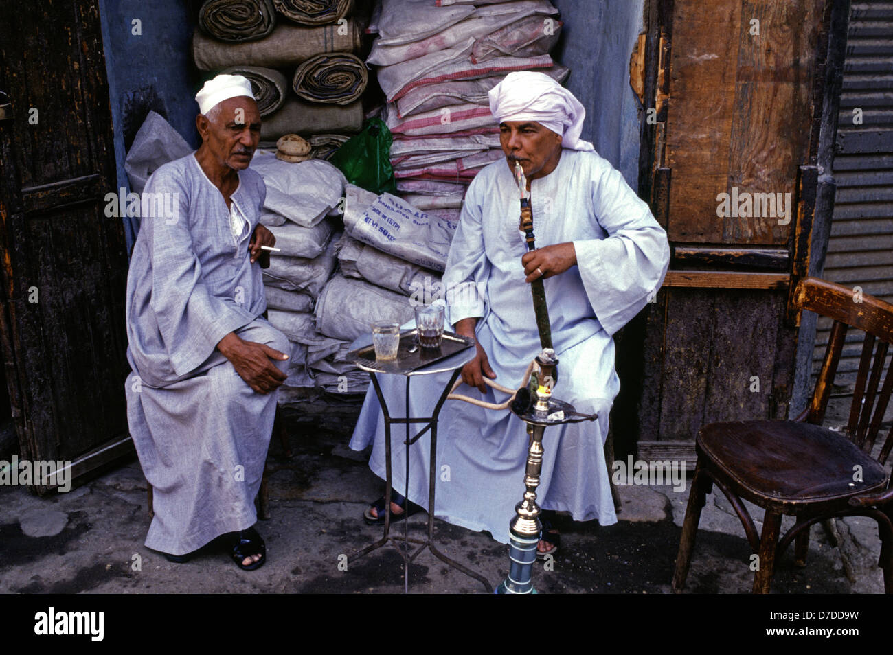 Egyptians wearing traditional Galabyeh garment and smoking Hookah pipe