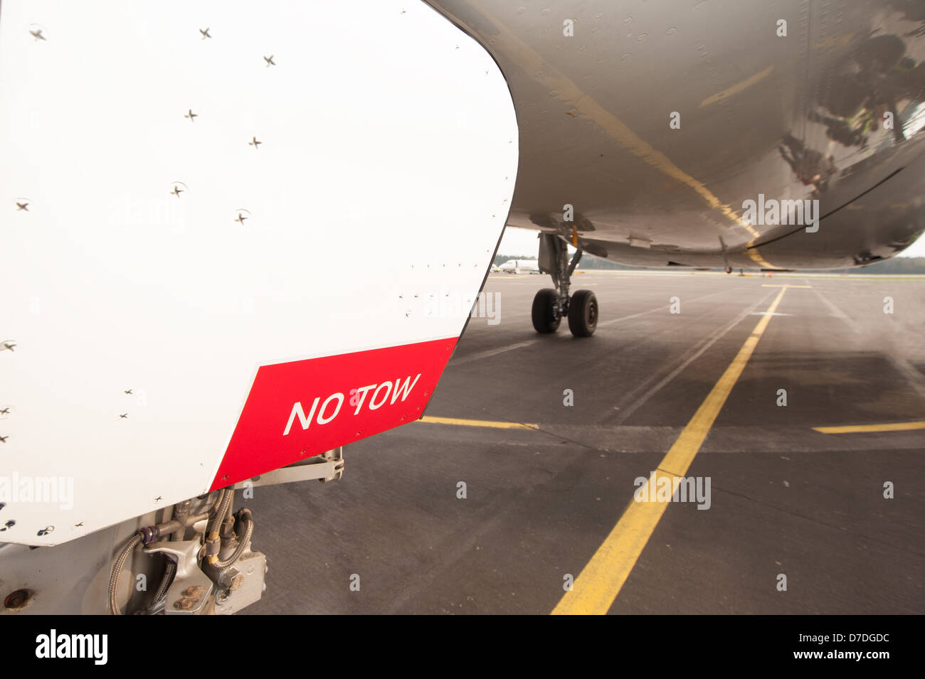 Sign NO TOW on undercarriage of airplane while waiting on runway Stock Photo