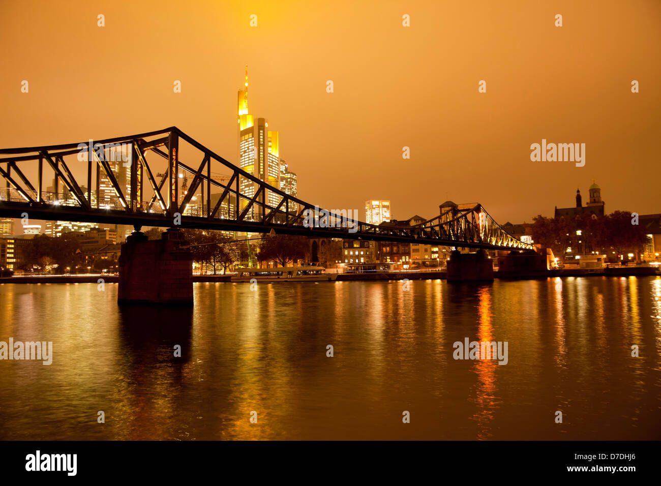 Eiserner Steg Bruecke, bridge over the Main river with the illuminated skyline of Frankfurt at dusk, Frankfurt am Main, Hesse, G Stock Photo