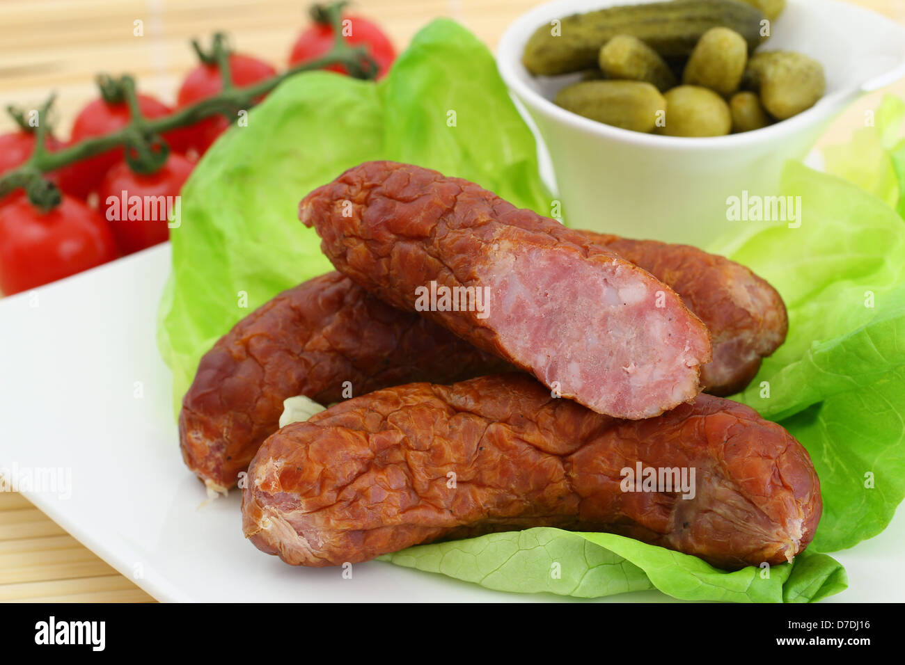 Traditional Polish smoked sausage on lettuce leaves Stock Photo