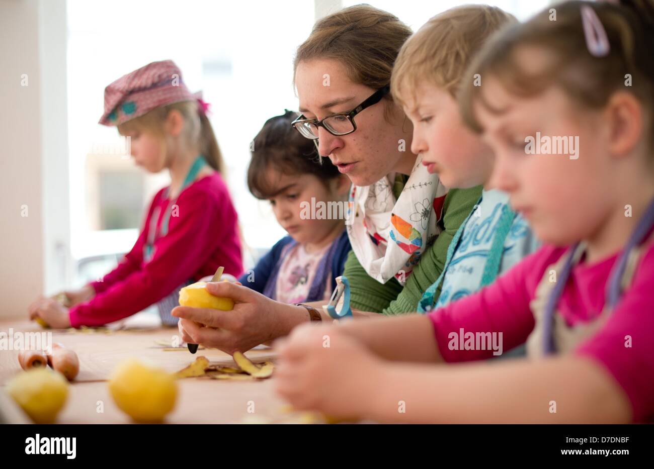 Simone Trockel cooks with Angelina (8, L-R), Elda (5), Alex (6) and Laurel (5) in the 'KinderKueche' in Hanover, Germany, 24 April 2013. Children cook their favorite dishes under the motto 'Self made meals are most tasty'.  Photo: Julian Stratenschulte Stock Photo