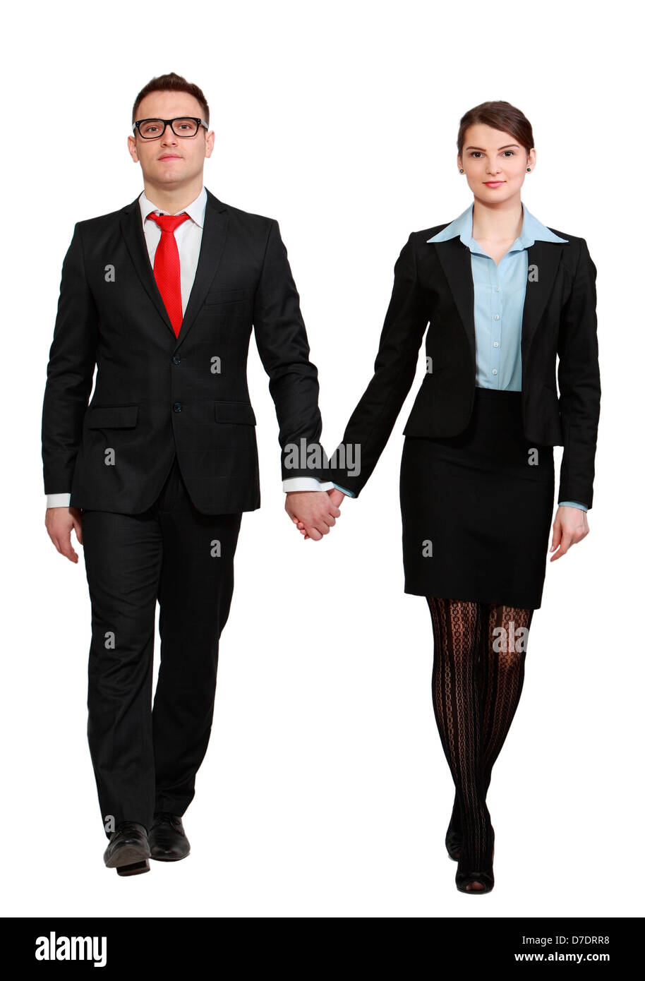 Young couple walking to the camera against a white background. Stock Photo
