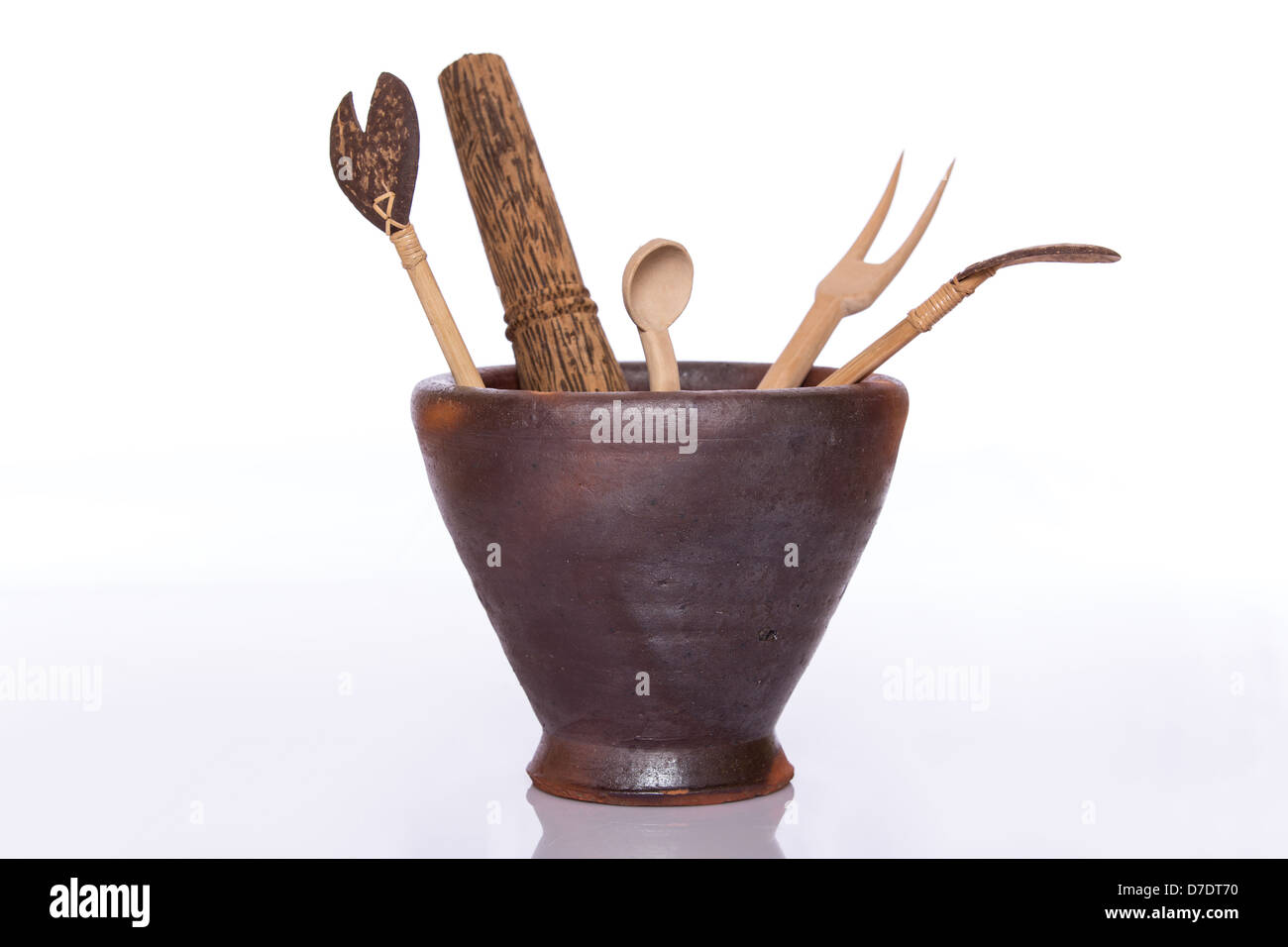 Kitchen wood tools in a ceramic jar on white background Stock Photo