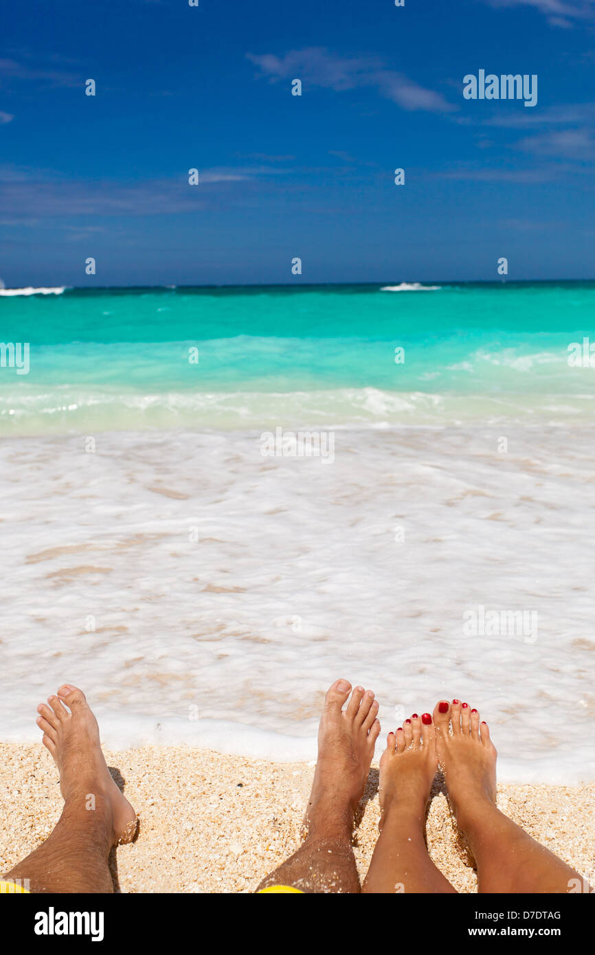 Male and female legs on tropical beach, closeup Stock Photo