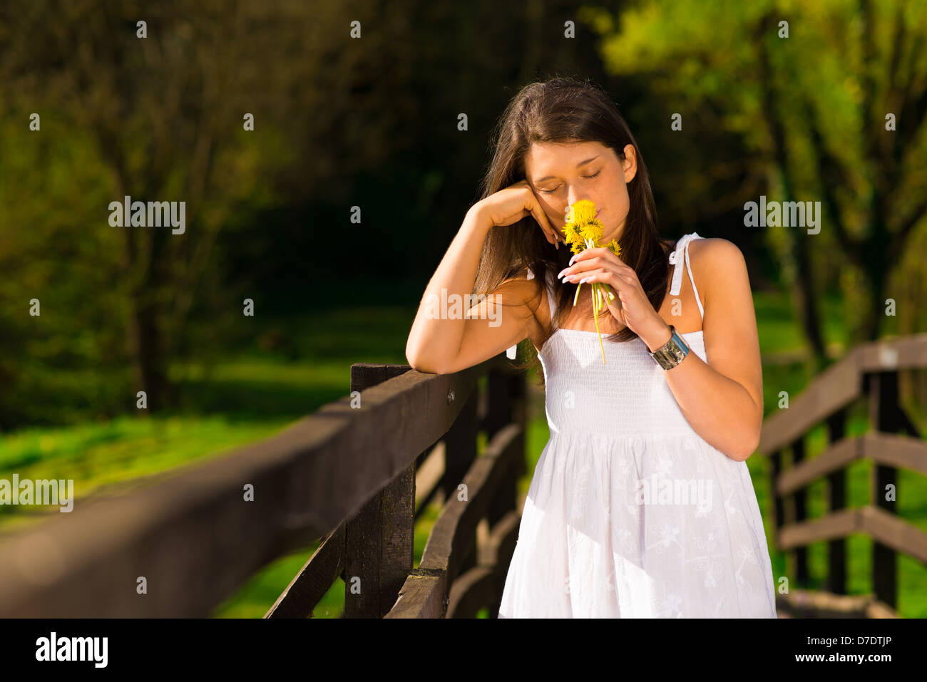 Smiling young woman holding some flowers happily Stock Photo - Alamy