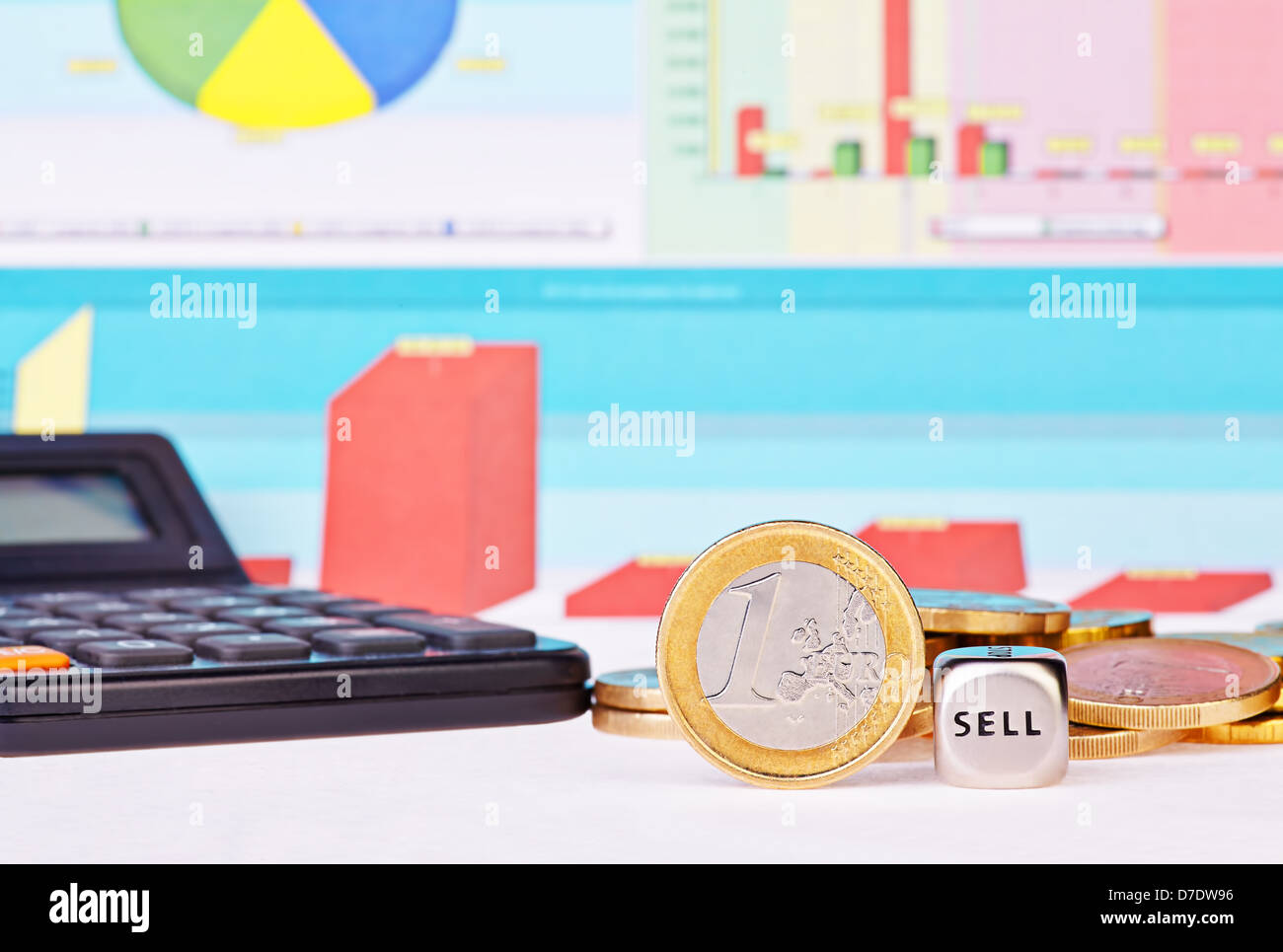 Dices cube with the word SELL, one-euro coin, calculator and financial diagrams as background. Selective focus Stock Photo