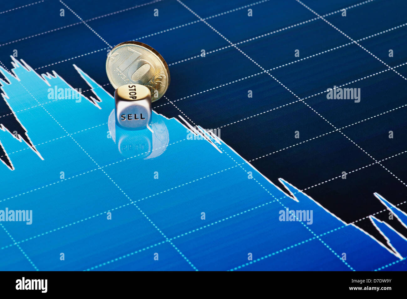 Downtrend chart with golden coin and dices cube with the word SELL. Selective focus Stock Photo