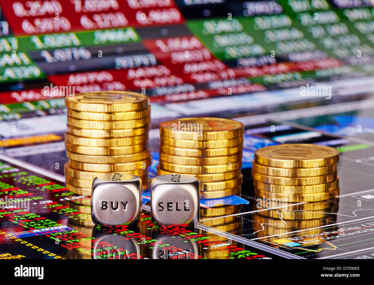 Stacks of coins, dices cubes with the words SELL BUY and down trend chart with the columns of figures as the background Stock Photo