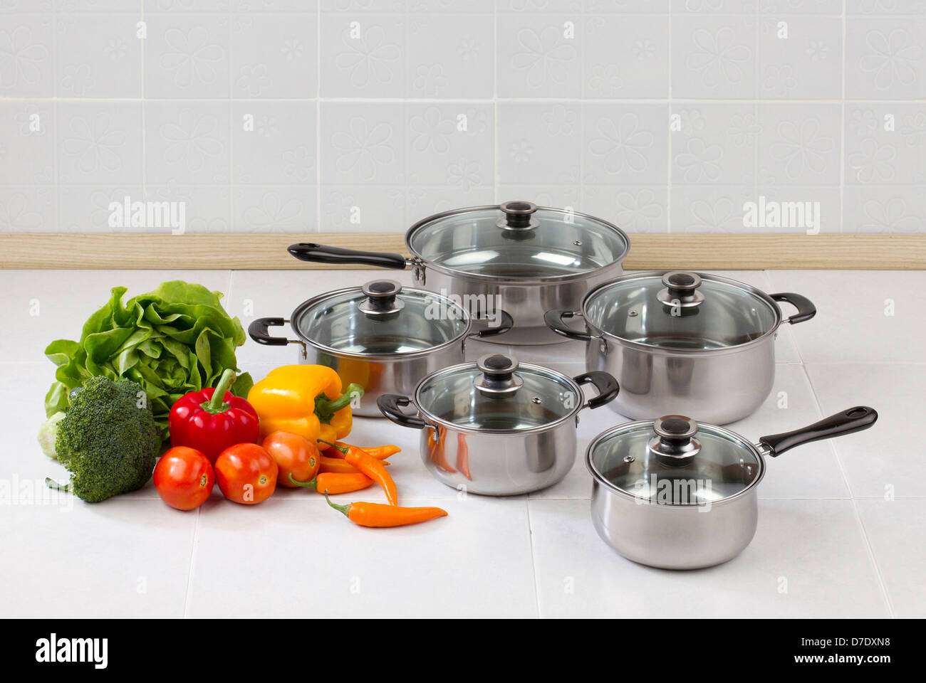 Set of stainless pots and pan with glass lids Stock Photo