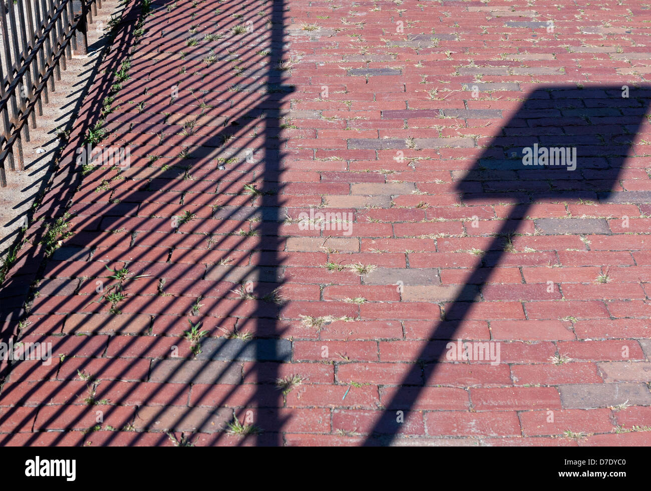 Sunlight creates interesting shadows on a brick walkway. Stock Photo