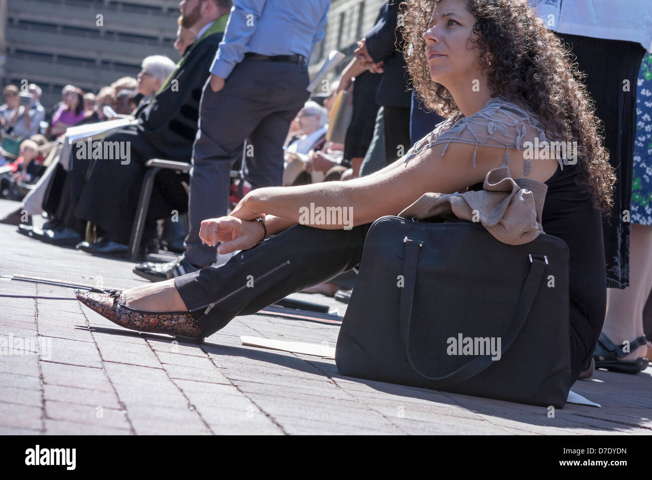 A woman listens intently during an outdoor memorial service in Boston. Stock Photo