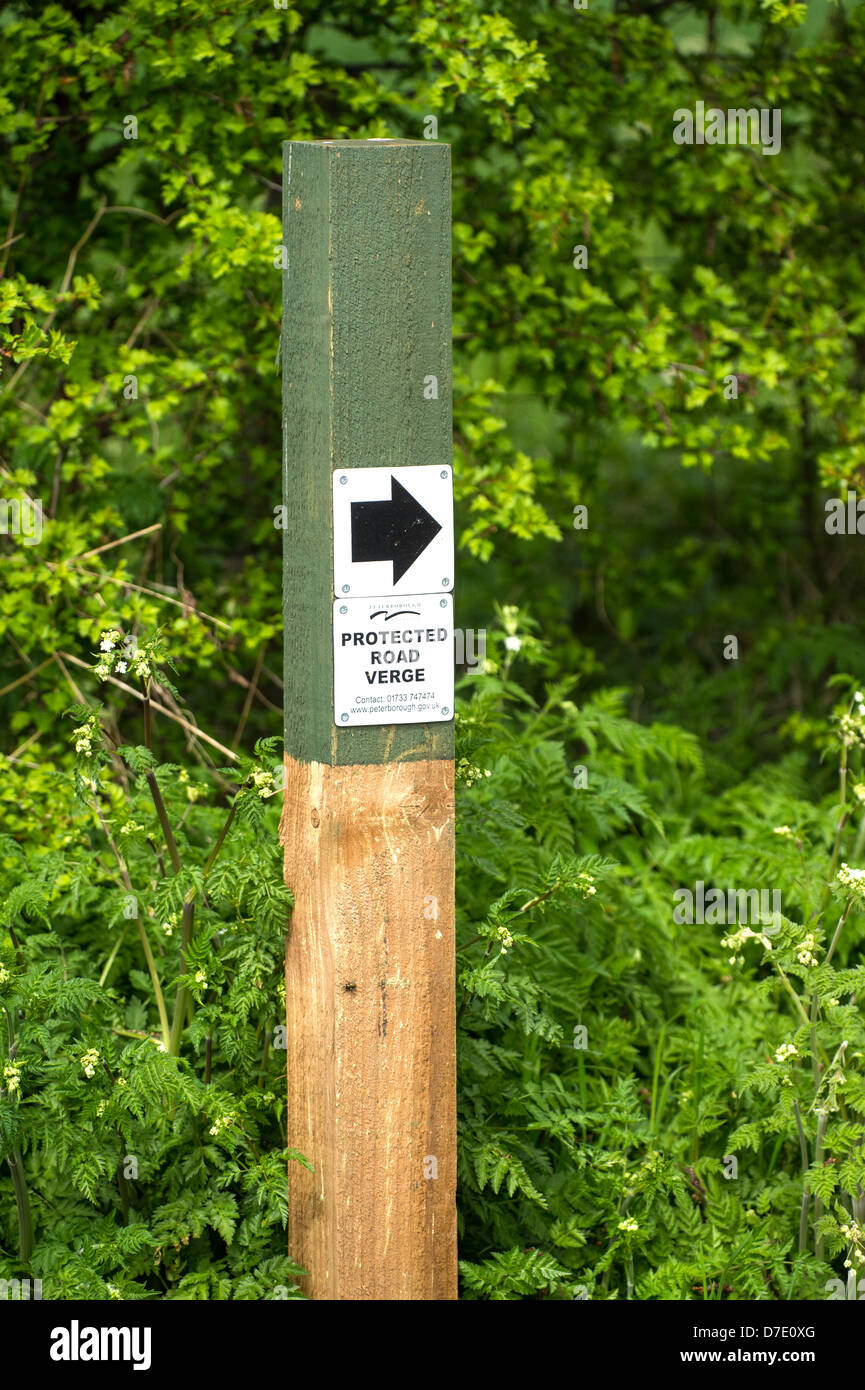 Sign post in grass verge indicating 'Protected road verge' Stock Photo