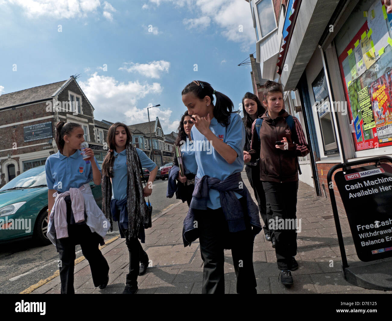 Teenage girls in uniform walking home together from school on a spring day in Cardiff City, Wales KATHY DEWITT Stock Photo