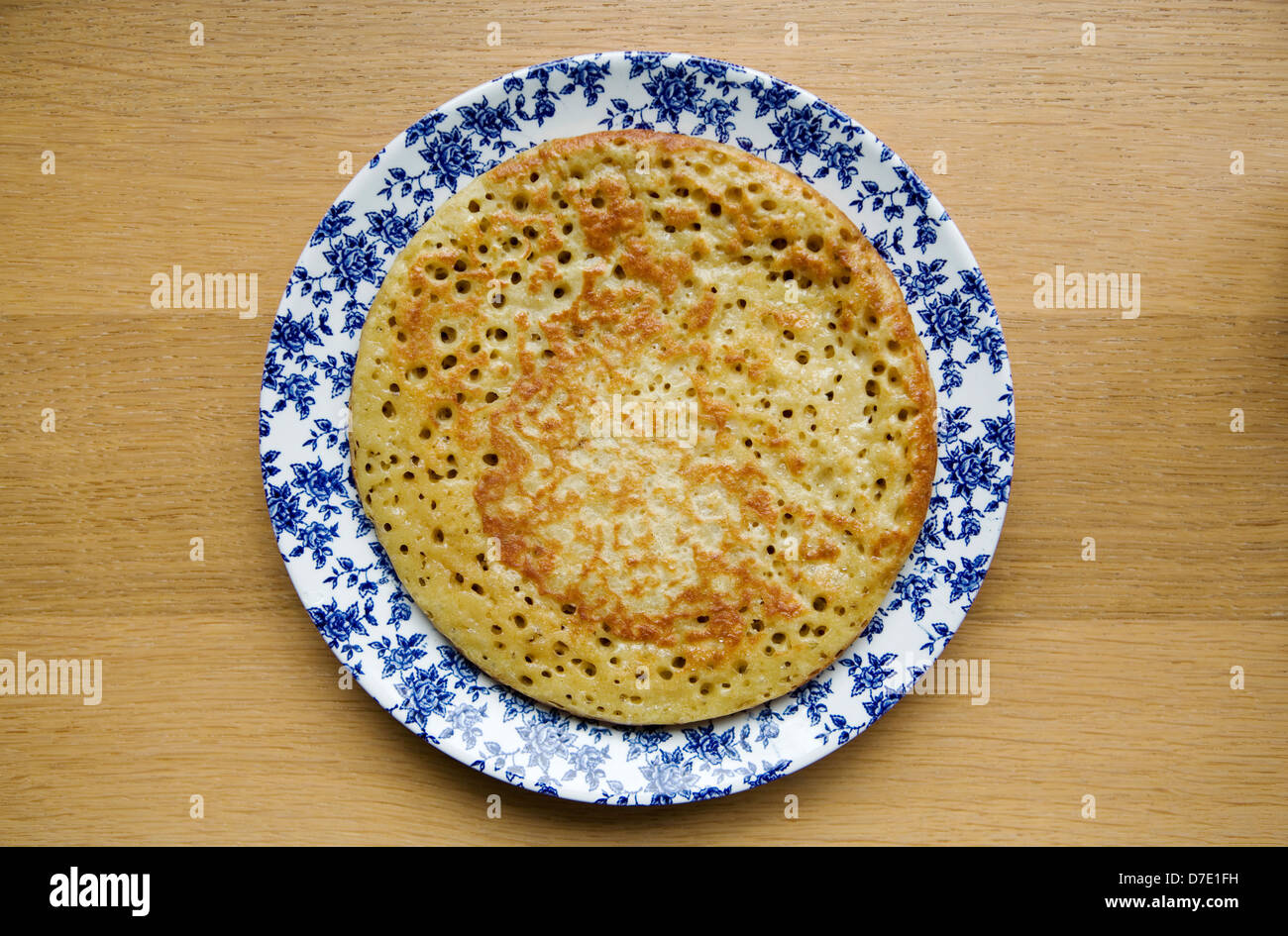 Homemade crumpet on a vintage floral plate Stock Photo