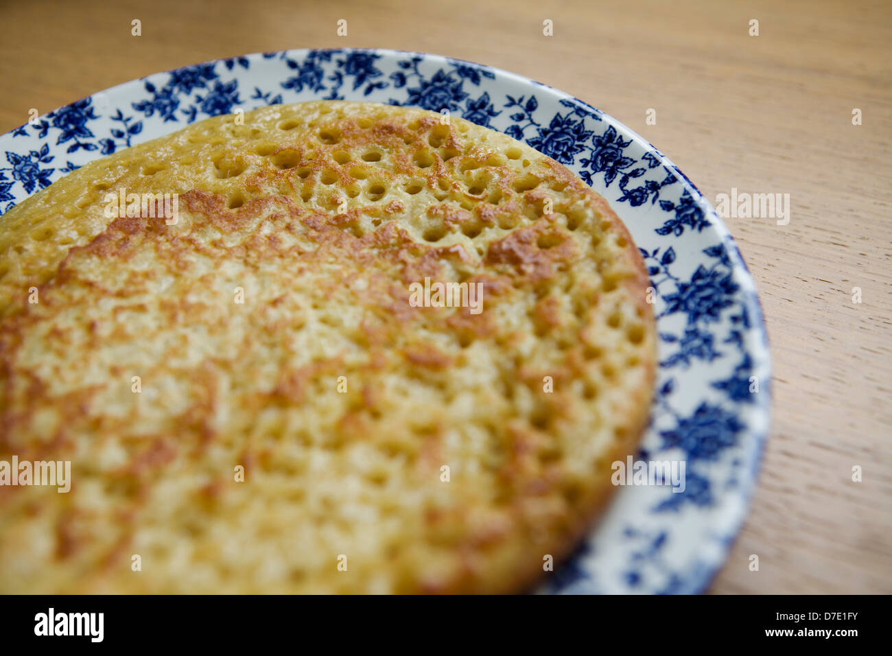 Homemade crumpet  on a vintage floral plate Stock Photo