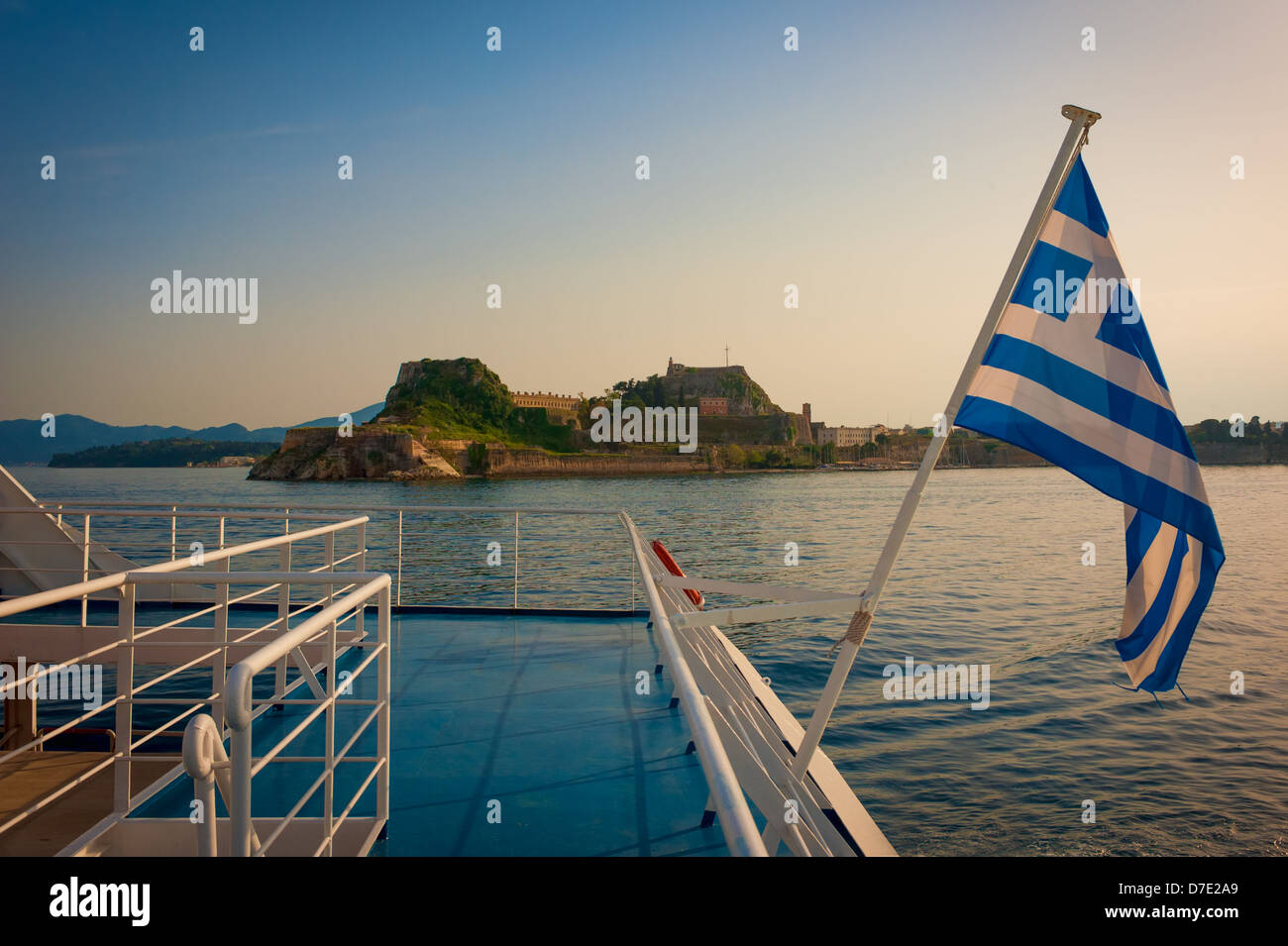 Corfu castle and Greek flag pictured in sunset from boat Stock Photo