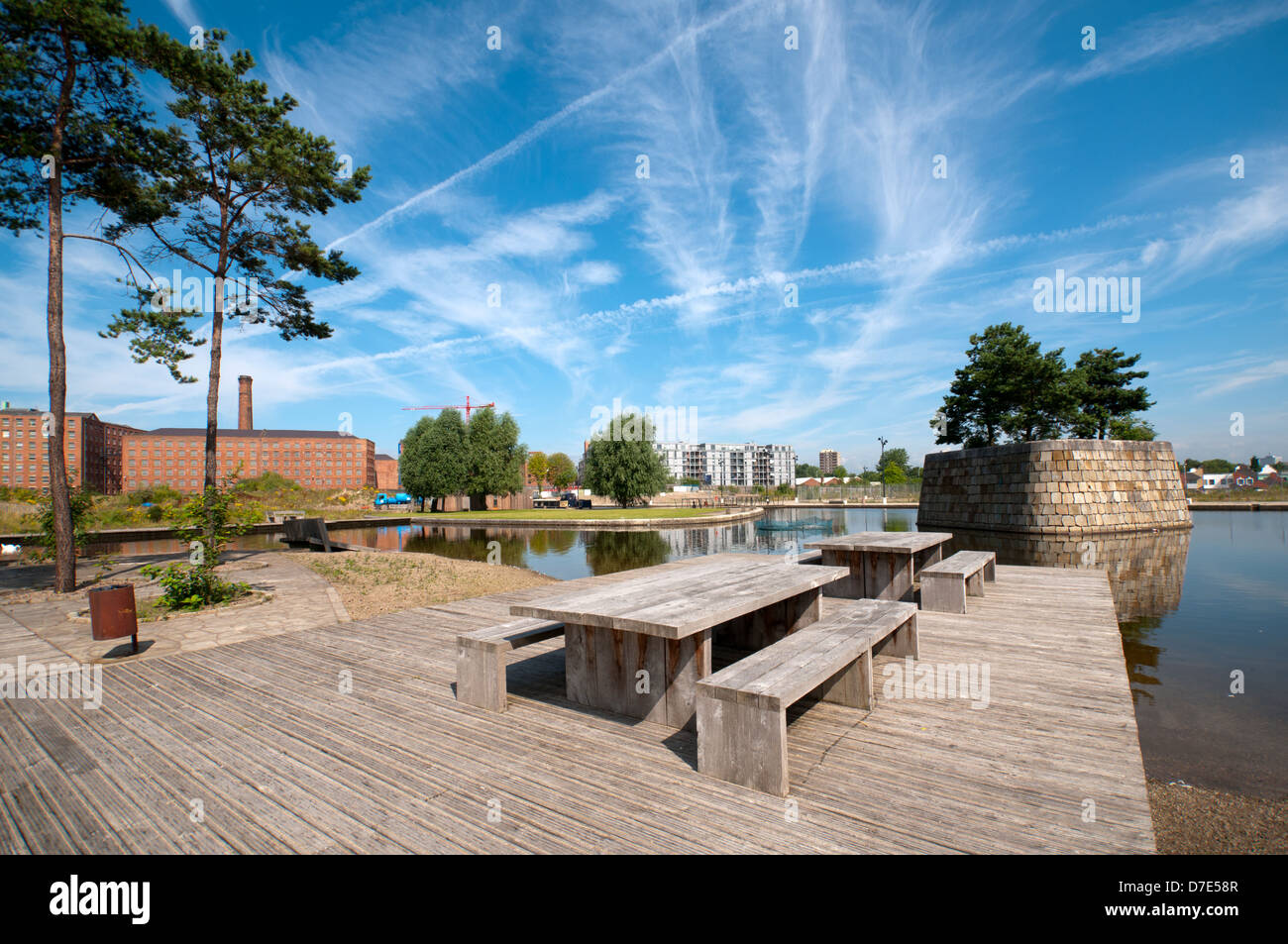 Cirrus clouds and picnic benches at the Cotton Field Park marina, New Islington, Ancoats, Manchester, England, UK Stock Photo