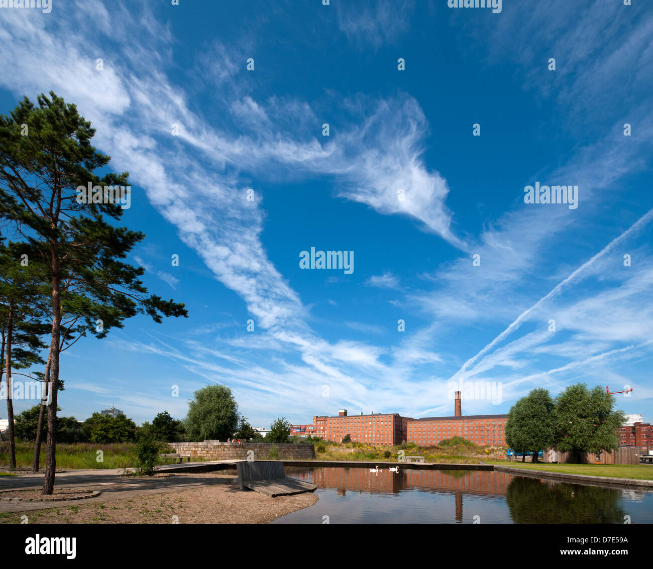 Cirrus clouds and former cotton mills reflected in the Cotton Field Park marina, New Islington
