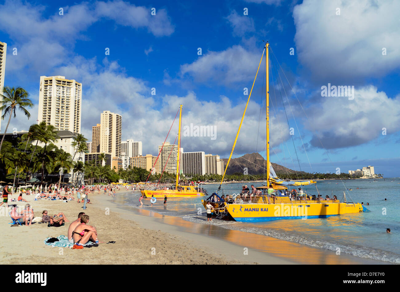 A catamaran prepares for a sunset voyage at Waikiki Beach, Oahu, Hawaii. Stock Photo