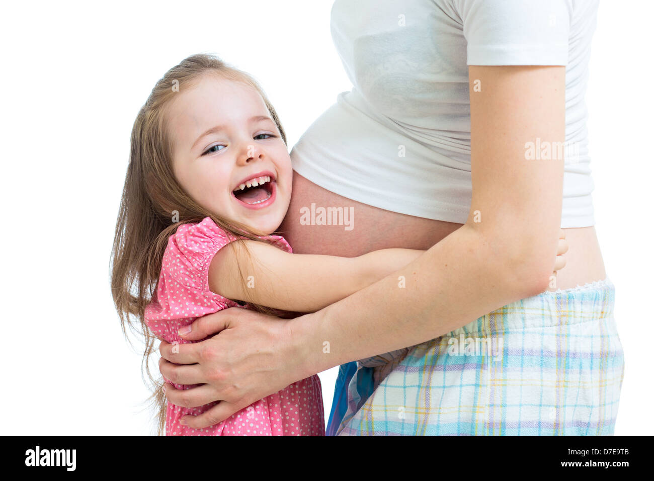 happy kid girl hugging pregnant mother's belly Stock Photo