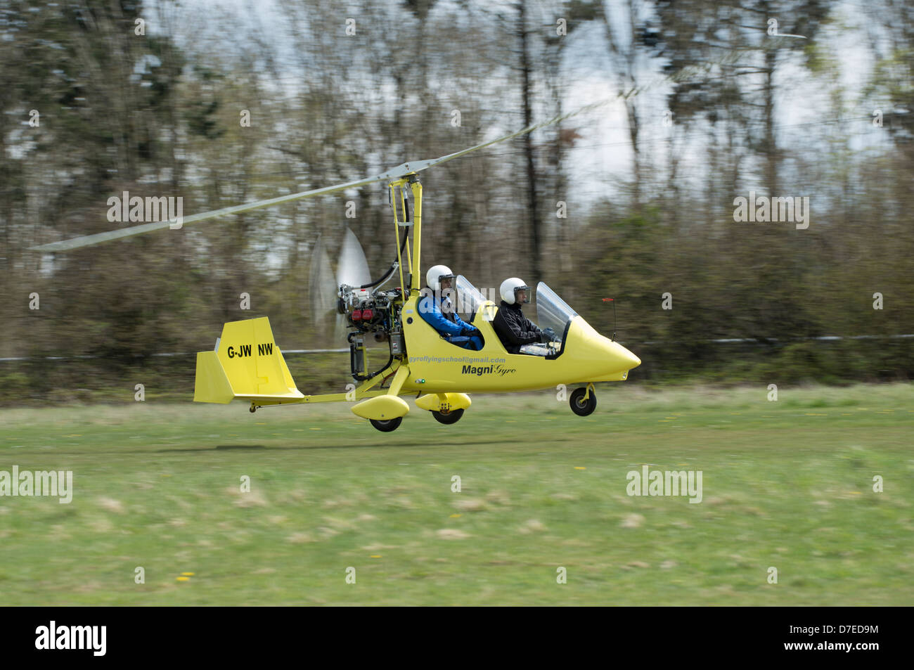Bright yellow Magni M16C Gyrocopter G- JWNW takes off from Popham Airfield near Basingstoke Hampshire Stock Photo