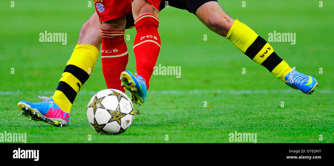 legs of football players of german clubs FC Bayern Munich and Borussia Dortmund fighting for champions league official match ball Stock Photo