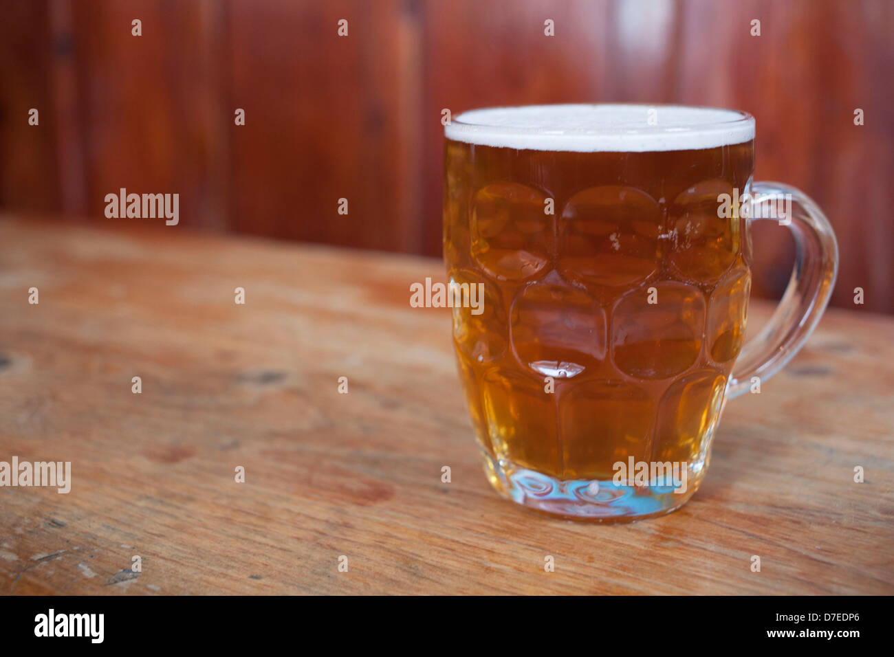 Pint of ale in an old fashioned jug beer glass. Stock Photo