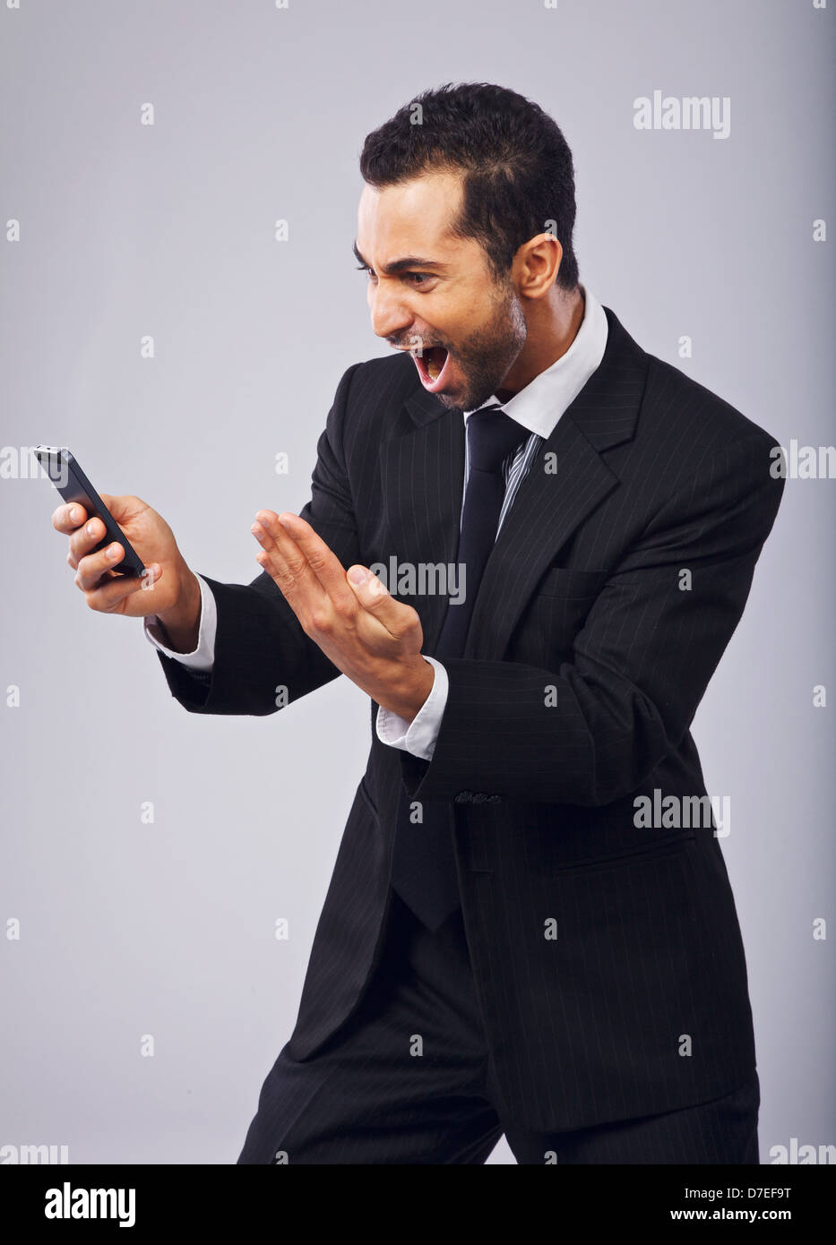 Ecstatic businessman screaming in excitement while reading sms from his cell phone Stock Photo