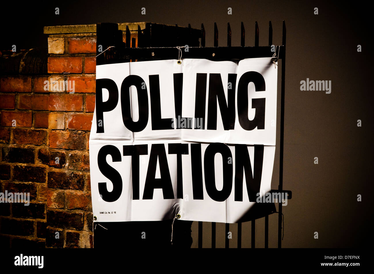 Polling Station temporary sign tied to a gate outside an English Polling / Voting Station viewed in the late evening night time. Stock Photo