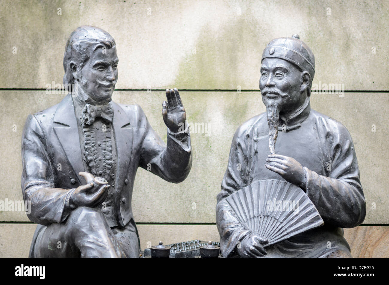 Statues representing the theme of 'East meets West': 19th Century Western and Chinese merchants converse over tea. Stock Photo