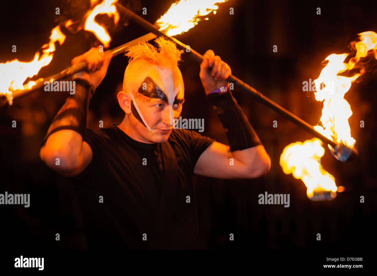 Man with face paint performing with fire in a parade Stock Photo