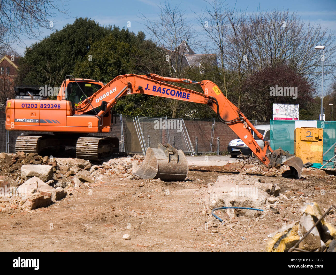 mechanical digger at work clearing rubble from a demolition site Stock Photo